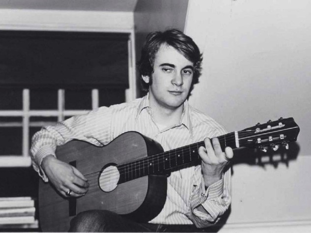 Photograph of William Randall playing guitar in his Lowell House room, c. 1970-1971