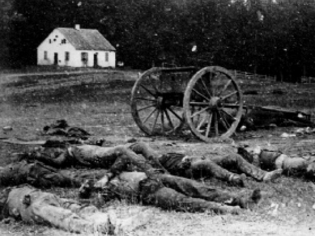 Dead Confederate artillerymen grouped near one of their limbers after Antietam. In the background is a Dunker church, built by a German Baptist pacifist sect.