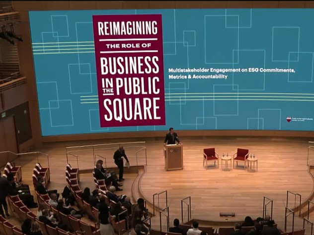 Audience members sit in a large auditorium at the start of the conference