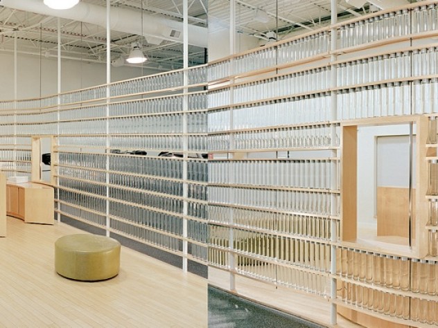 Photograph courtesy of MERGE architects Stacks of Voss water bottles form a translucent curving wall at a health club.