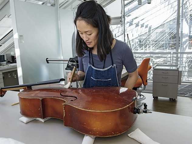 Photograph by Jim Harrison Angela Chang, assistant director and conservator of objects and sculpture, readying a cello for display.
