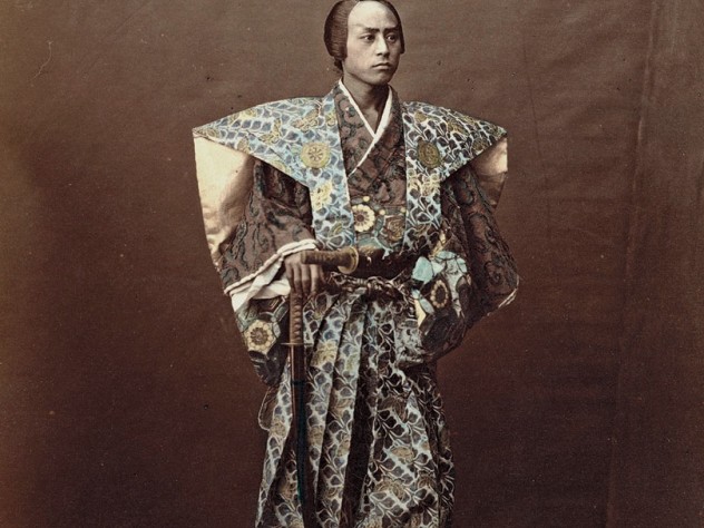 1870s Japan: a hand-tinted albumen print by Raimund von Stillfried showing a man costumed as a samurai warrior