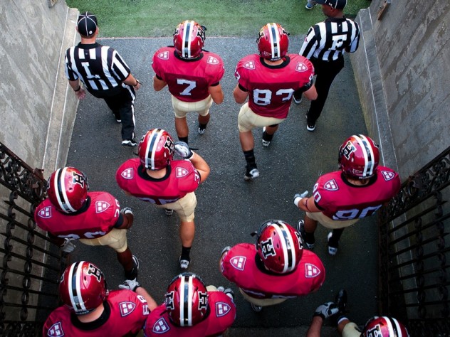 Photo of Harvard football players heading onto the field