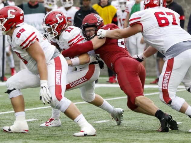 Harvard's Brogan McPartland breaks through to tackle Cornell quarterback Richie Kenney for a loss. In his first 2019 appearance, the senior defensive lineman had two of the Crimson's six sacks.