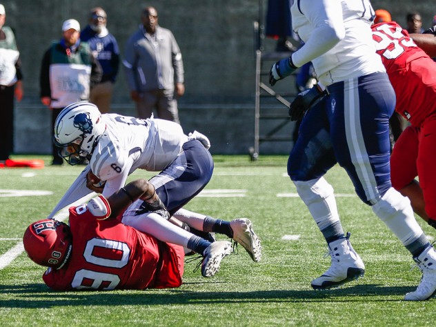 Harvard's Truman Jones drags down Howard quarterback Quinton Williams.