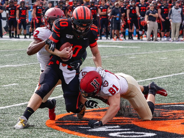 Isaiah Wingfield and Brogan McPartland of Harvard tackle Princeton quarterback.