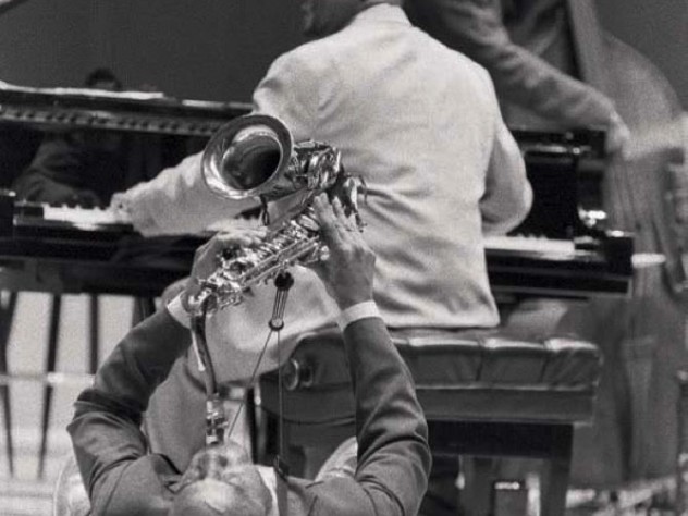 Walter Blanding “demonstrating Coltrane,” 2002. Jazz artist Walter Blanding playing the saxophone on his back on the floor, "demonstrating" styles of John Coltrane, 2002