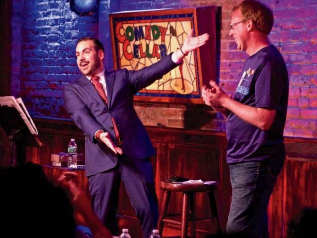 Greenbaum excitedly gesturing toward an audience member on stage at the Comedy Cellar