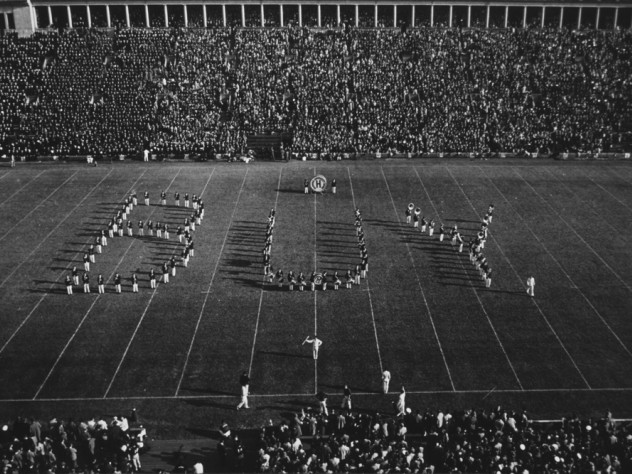 Band in formation spells out "BUY..."