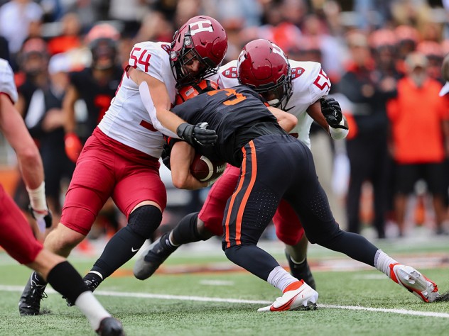 Two Harvard linebackers tackle a Princeton receiver