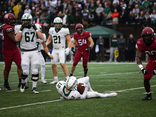 Truman Jones celebrates a tackle with Derek Kyler lying on the ground beside him.