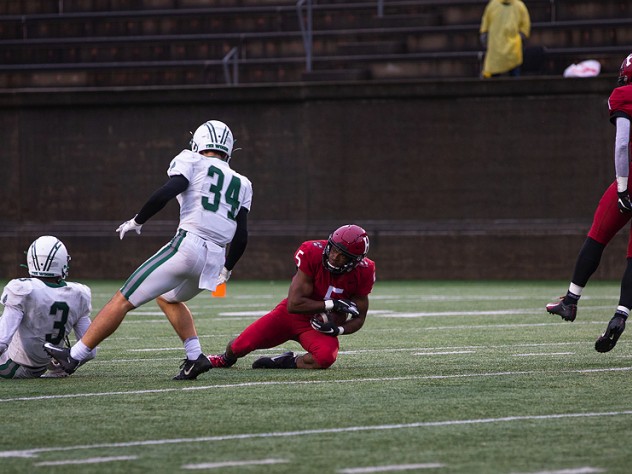 Harvard's B.J. Watson falls to the ground with the ball.