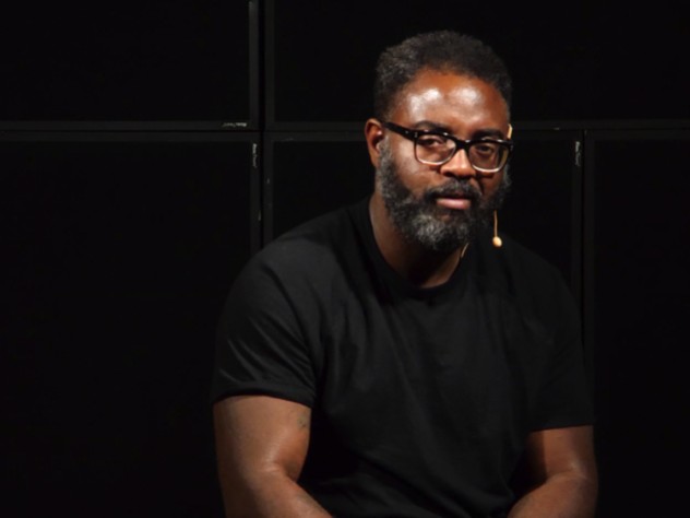 Reginald Dwayne Betts seated in front of a black background