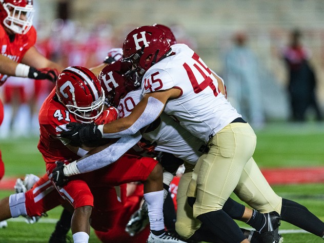 Cornell running back Eddy Tillman finds his path blocked by Harvard defenders. The Crimson limited the Big Red to 65 yards on 37 carries.