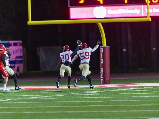 Senior Kobe Joseph, who broke in and blocked a Cornell punt,accompanies junior Jelani Machen as he holds the ball aloft and runs into the end zone to give Harvard a second-quarter lead.
