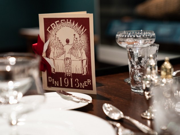 A table with a fancy menu and table settings.