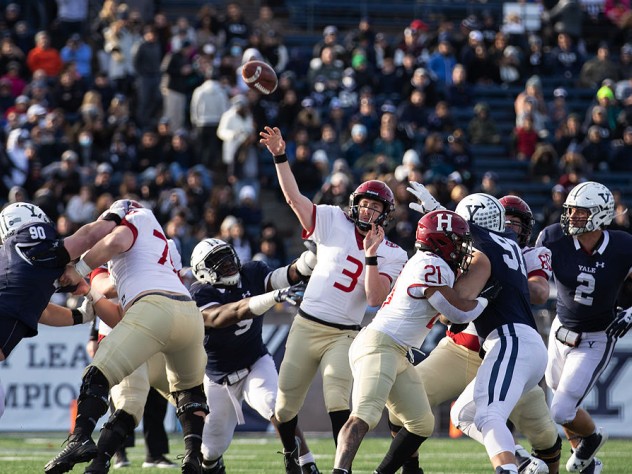 Luke Emge throws the football amidst Yale defenderss