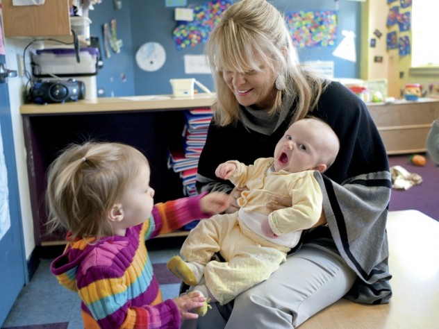 Mary Kinsella Scannell, vice president for early education and care, plays with baby Kinsey Ferraguto and toddler Margot Vorhees.