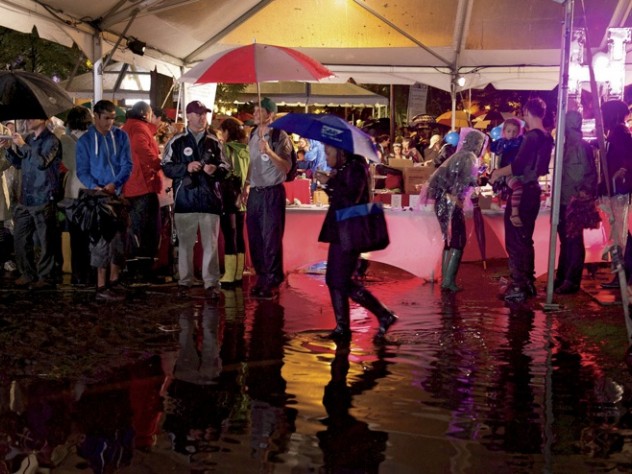 Photograph by Jim Harrison Harvard Yard had more standing water than solid ground, and partygoers gathered under the food tents to stay dry during downpours.