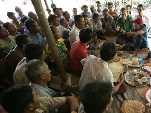 Debbie Aung Din Taylor (with red hat), co-founder of Proximity Designs, meets with villagers in A Phaung Gyi, in Dedaye township in the Ayeyarwaddy River Delta. Many of the villagers use crop loans provided by Proximity Designs to plant rice. It also provides agricultural advice, and now distributes a line of popular, low-cost solar lights (90 percent of Myanmar's rural households are not on an electrical grid). 