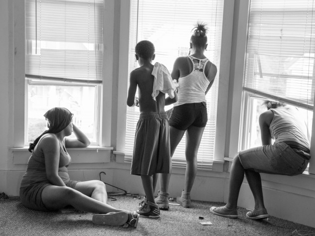 Photograph by Michael Kienitz While being evicted from her Milwaukee apartment, Danielle Shaw (left) and relatives wait until the movers carrying down her refrigerator and stove are no longer blocking the stairwell.