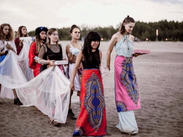 A procession of women heading toward a lake