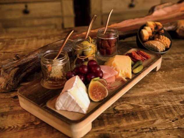 A platter of cheese, cured meats, and fruit