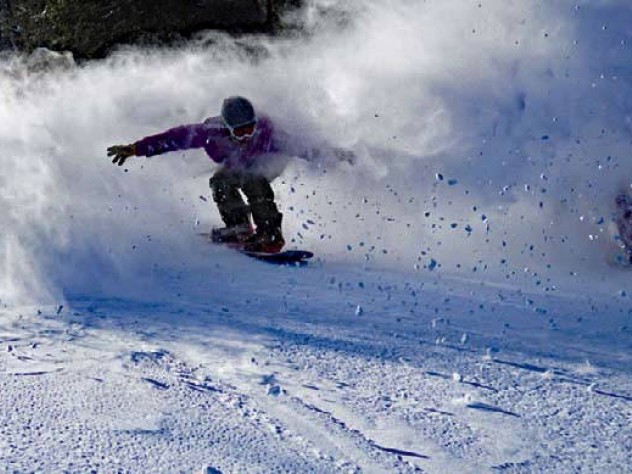 Skier coasting down the mountain with snow sprays