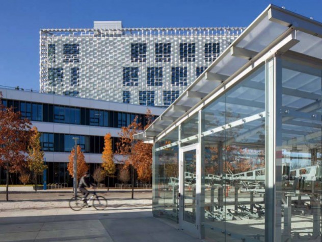 A photograph of a glassed-in bicycle storage facility, a key part of the transportation plan linking the complex to the Cambridge campus.