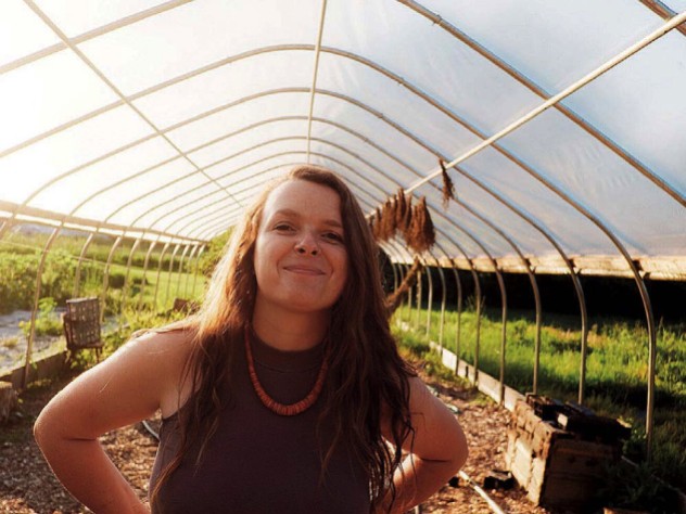 Reid Parsons stands in a greenhouse amid plants