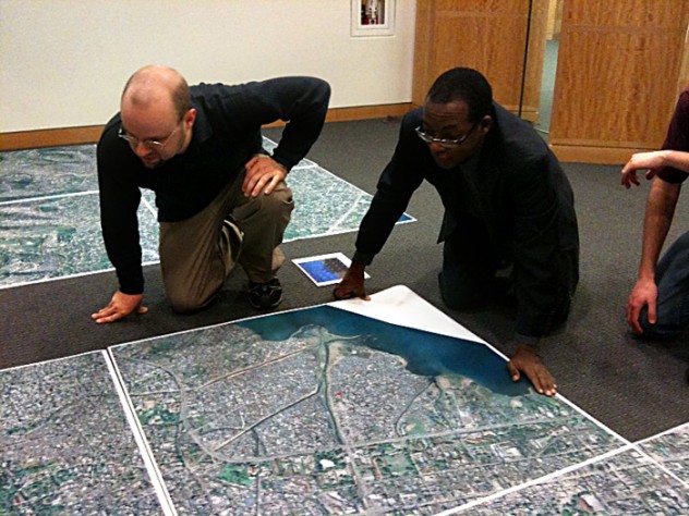 At the Center for Geographic Analysis office, the Harvard-MIT Data Center's Eric Alderman examines a map of Port-au-Prince with Jean-Lucien Ligonde, a businessman in the Boston Haitian community, in preparation for sending the map to Haiti to be used in relief work.
