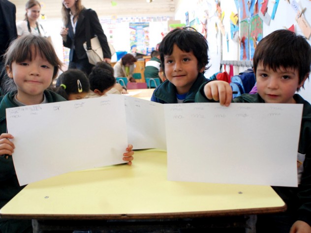 Children in a UBC classroom display a writing exercise on which they've been working. 