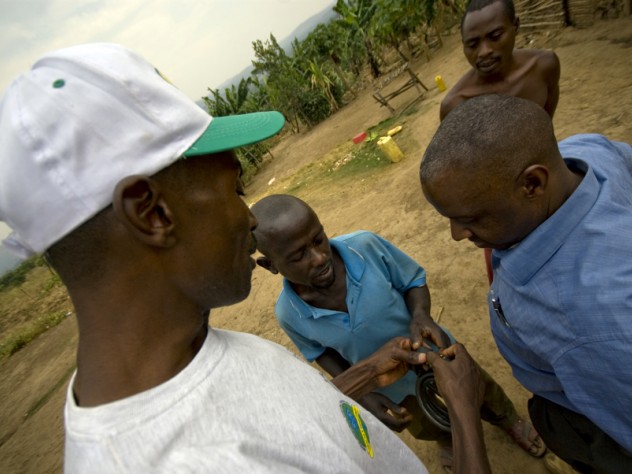 Photograph by Ian MacLellan Barigye goes by bicycle to the clinic for his antiretroviral prescriptions and doctor appointments. After his bicycle was stolen twice, SHIP director Elijah Musinguzi gave Barigye a gift: this bike lock. At right is Ibrahim Kiviri, a driver for the partnership between Harvard and Mbarara University of Science and Technology (MUST).