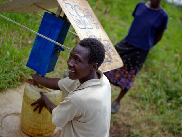 Photograph by Ian MacLellan At another collection site near Busia, Loice Pamba adds chlorine before filling her water jug.