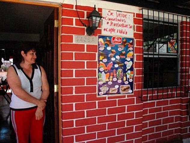 Herrera stands in the doorway of her home.