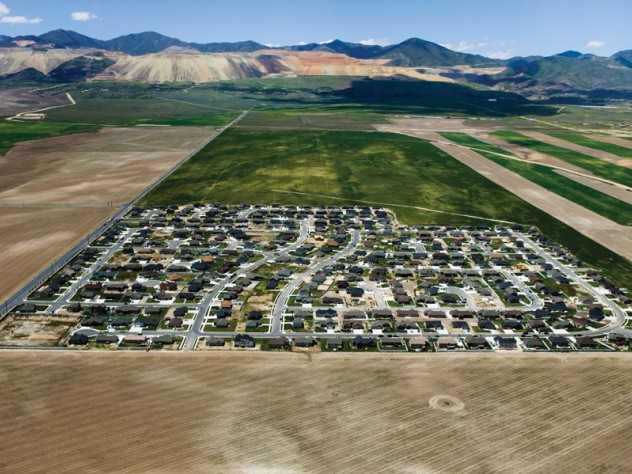 Photograph and caption by Alex MacLean South Jordan, Utah - Isolated exurban communities built on cheap agricultural land depend on cars for nearly every activity. To access urban centers, residents often have to commute long distances. Because the land is virtually undeveloped, all aspects of modern infrastructure (water, sewer, electric, and roads) must be extended.