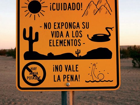 Near Winterhaven, California, an official sign faces south to warn illegal immigrants of dangers in the desert trek&mdash;heat, rugged terrain, rattlesnakes, lack of drinking water, a chance of drowning in a nearby canal&mdash;adding that it is not worth the risk.