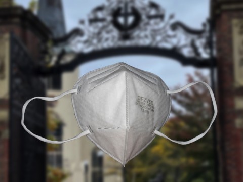 n95 mask in the foreground, Harvard Yard in the background 