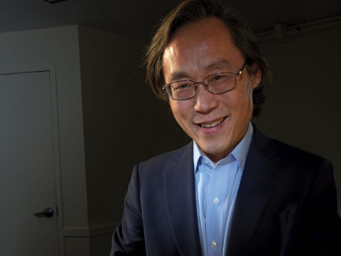 Frank Hu holds a plate filled with food.