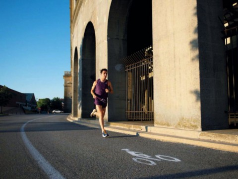 A man runs around the perimeter of Harvard Stadium