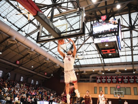 Chris Ledlum dunks the ball in the basket as opposing players trail behind him