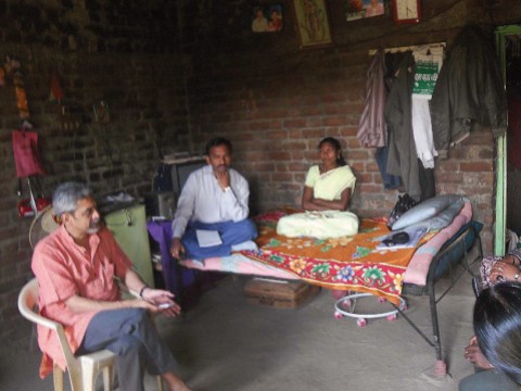 Photograph of Vikram Patel visiting with family members of a farmer in Maharashtra, India, who committed suicide