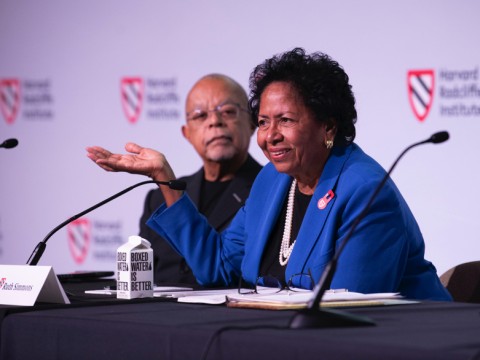 Ruth Simmons sits at a table on the stage with Henry Louis Gates, Jr.
