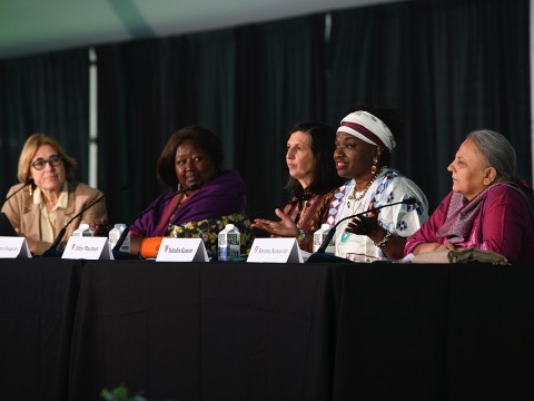 Moderator Jacqueline Bhabha seated at a table with panelists Agnes Binagwaho, Abby Maxman, Natalia Kanem, and Reema Nanavaty.