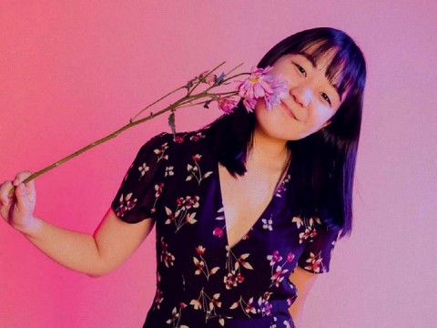 Karen Chee holding a flower to her face