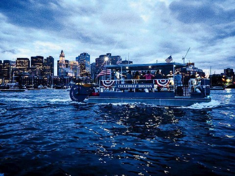 Boat cruising on Boston harbor at twilight 