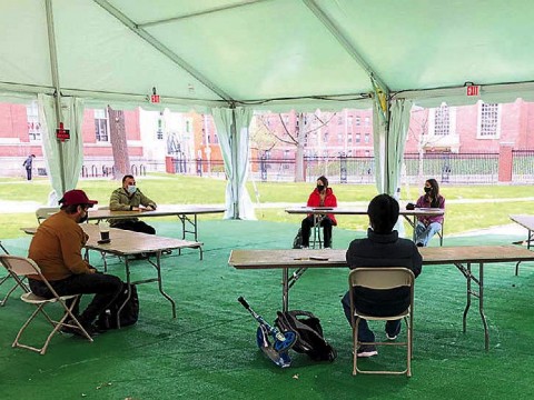 Photograph of teaching a playwriting class under a tent outdoors