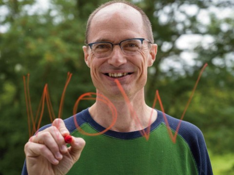 Mark Saltveit writes "Wow" on a piece of glass