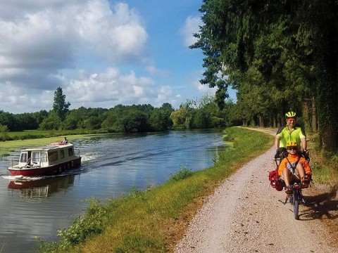 Michael Lyon and son ride a bike next to a river.