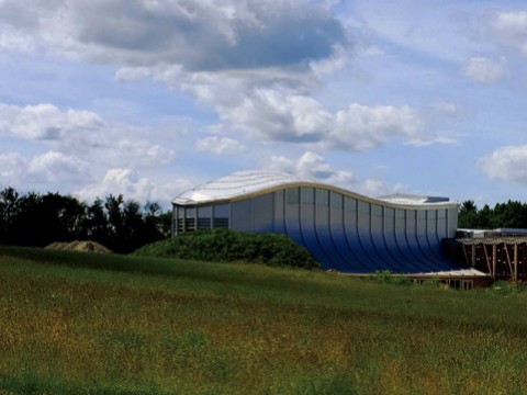 blue skies and green fields and music center building 